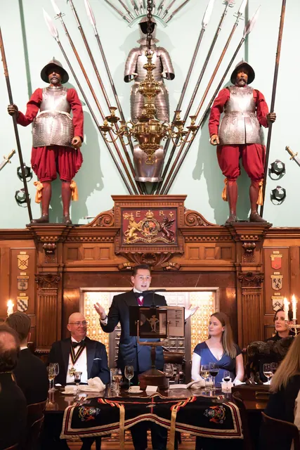 Delivering a Coopers' Company speech, flanked by the Company's yeomen guards.